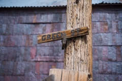 Photo of the Green Street Sign in Bodie, CA.  The shingles in the background are flattened out food cans and are over 100 years old.